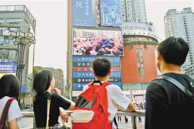 4月17日，沙坪坝区三峡广场，市民收看习近平总书记在重庆考察的新闻。.jpg